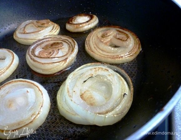Лук нарежем кольцами и обжарим до золотистого цвета. Можно с кольцами не заморачиваться, а просто нарезать четверть кольцами. Выложить обжаренный лук, а на сковороде поджарить разрезанную булочку мякишем вниз.