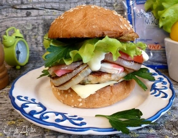 Собираем бургер «Крабовый Луи». На теплую булочку кладем сливочный сыр (он у меня в пластинках), мясную котлетку, крабовое мясо, обжаренный лук, колечки помидора и авокадо. Сверху этой пирамиды кладем лист салата и листики петрушки. Закрываем второй половиной булочки.
Подаем к столу! На здоровье!