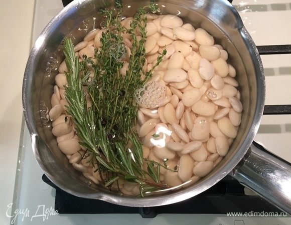 Пока варится фасоль, очистить чеснок и лук, мелко порезать. Возьмите глубокий сотейник, в котором будет готовиться рагу, и разогрейте пару ложек оливкового масла. Слегка обжарить лук и чеснок.