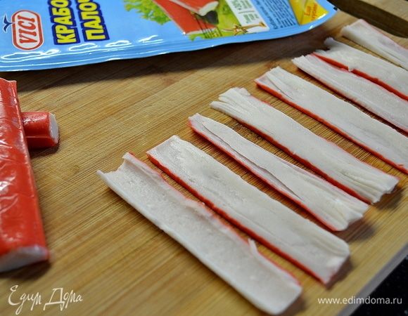 Начнем с чипсов. Крабовые палочки VICI нарежьте на как можно тонкие полоски.
