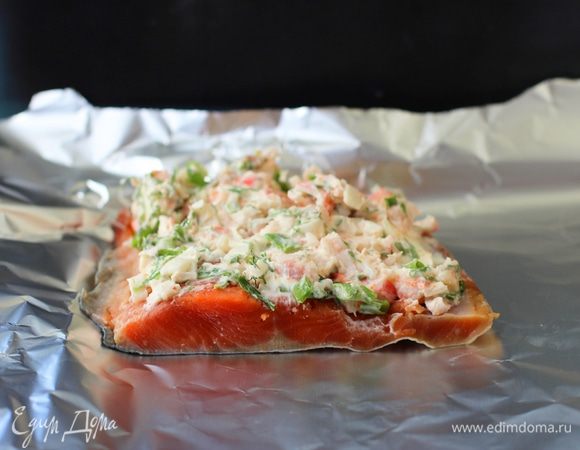 Смешать маскарпоне со всеми ингредиентами для «шубы», включая крабовые палочки с креветками. Противень выстелить фольгой, разложить лосось кожей вниз на противне, равномерно выложить «шубу» на все порции рыбы.