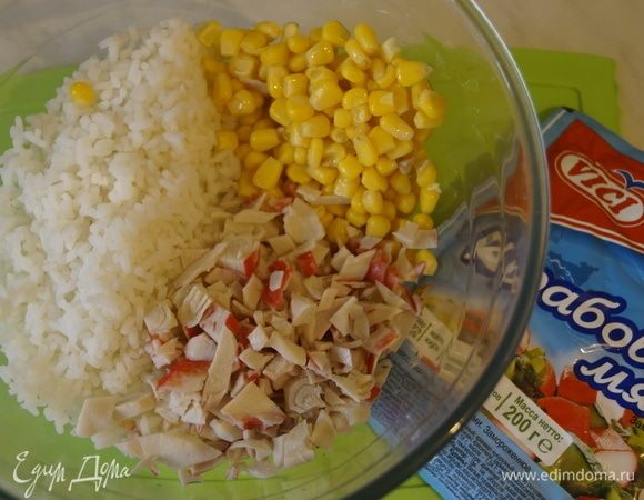 Выложить рис, порезанное крабовое мясо и кукурузу в чашу.