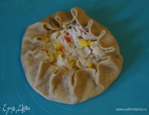 На середину пласта выложить часть начинки и сформировать бортики. Так поступить и с остальным тестом. Выложить галеты на противень, застеленный пергаментом.