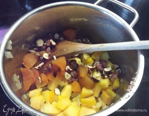 Добавляем нарезанную курагу, колотый фундук и обжариваем еще минуту.