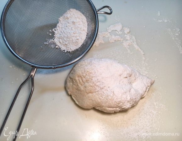Половину оставленной муки рассыпьте на столе. Выложите на нее тесто. Смажьте маслом руки и вымешивайте тесто, постепенно добавляя оставшуюся муку. На это у вас уйдет примерно 7 минут, пока тесто не станет тугим и гладким.
