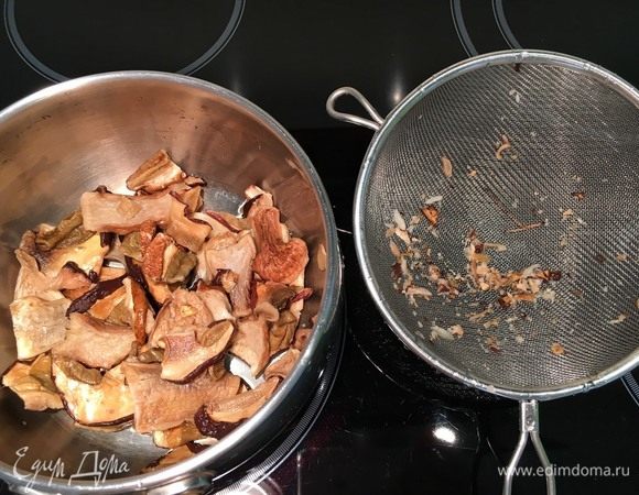 Грибы нужно подготовить для начинки. Высыпьте их в сито или дуршлаг и хорошо промойте под струей воды. Переложите их по одному в кастрюлю, таким образом сор не попадет в бульон.