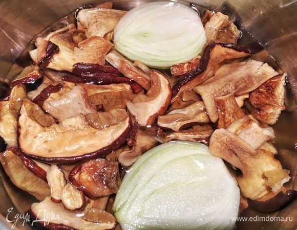 Залейте грибы холодной водой. Она должна слегка покрывать их. Добавьте к ним луковицу и гвоздику. Оставьте замачиваться на полтора часа. За это время грибы вспомнят свою текстуру и увеличатся в размере. Затем в эту же воду добавьте гвоздику и варите на слабом огне 1,5 часа (гвоздику через 45 минут можно вынуть, чтобы она не перебивала запах начинки).