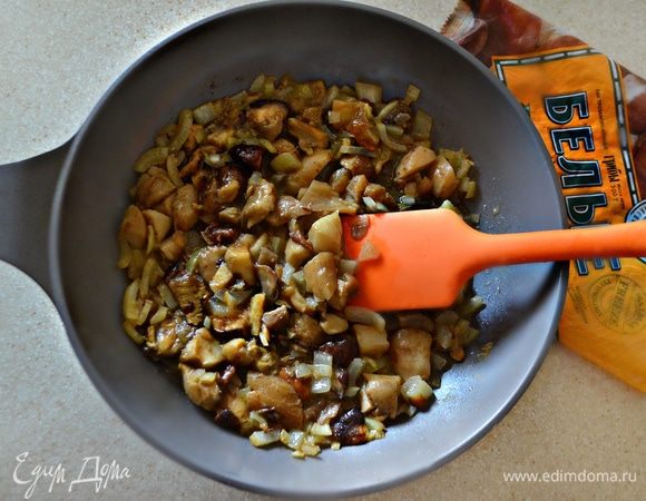 Грибы разморозьте, порежьте на небольшие кусочки и добавьте к луку. Приправить солью, перцем. Тушите вместе в течение 15-20 минут (лишняя жидкость должна выпариться). Начинку остудите.