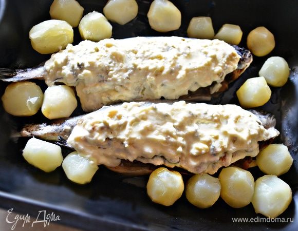 Выложите сметанный соус поверх рыбок, отправьте в разогретую до 180°С духовку на 35 минут.