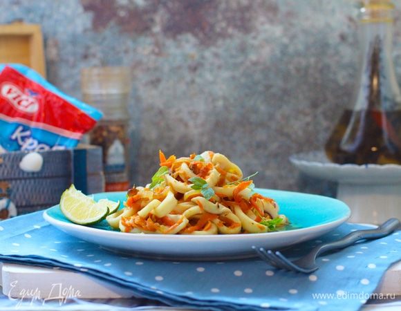 В сотейнике разогреть растительное масло. Слегка обжарить лук, всыпать морковь, добавить соевый соус, табаско и потомить овощи на среднем огне до мягкости. 
Добавить кальмары и крабовые палочки, лимонный сок, специи, попробовать на соль и при необходимости досолить (я предпочитаю добавлять соевый или устричный соус, но тут на любителя). Все перемешать, оставить на огне на 1 минуту.
В конце добавить сливочное масло, перемешать, снять с плиты и оставить под крышкой доходить. Овощи и морепродукты напитаются сливочным маслом, собственным соком и приправами.