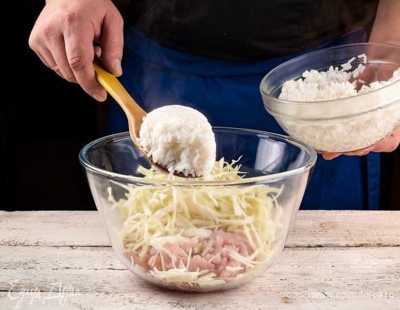 В глубокой емкости соедините рис, лук, куриный фарш, капусту. Добавьте специи по вкусу и все хорошо перемешайте. Форму для запекания смажьте оливковым маслом, выложите в нее основу для запеканки и хорошо утрамбуйте, выравнивая поверхность.