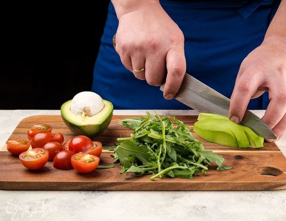 Авокадо очистите и нарежьте небольшими кубиками. Помидоры черри разрежьте пополам. Руколу порвите руками.
