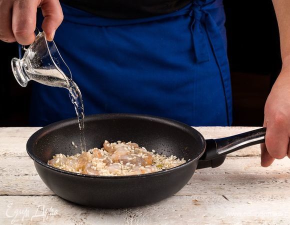 Добавить в рис вино, подождать, пока оно выпарится.