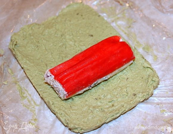 На застывшую массу из авокадо выкладываем застывшую фаршированную крабовую палочку.