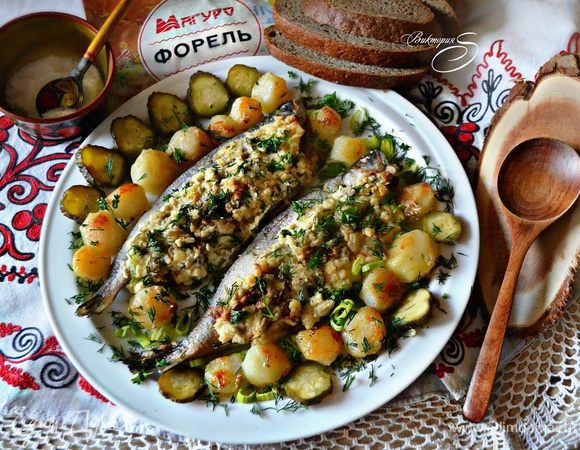 Готовую форель вместе с картофелем выложите на блюдо, украсьте солеными огурчиками и зеленью. Приятного аппетита и мир Вашему дому!