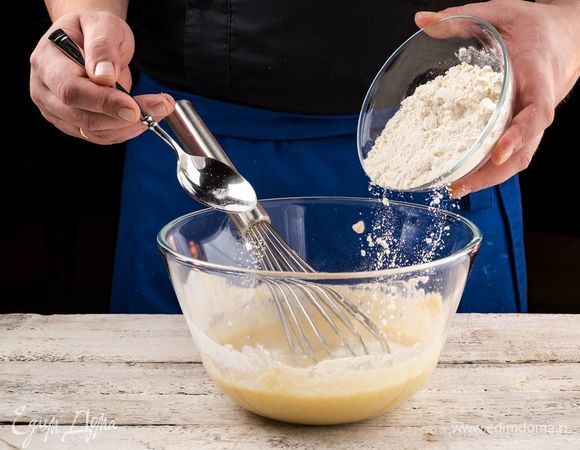 Смешайте муку с содой и постепенно высыпайте в смесь.