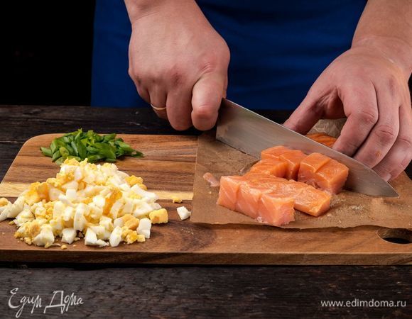 Филе семги очистите от кожи и костей. Нарежьте кубиками. Яйца для начинки отварите и мелко нарежьте, измельчите зеленый лук. 