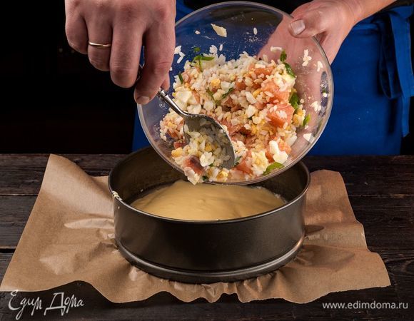 Форму для выпечки диаметром 30 см застелите пергаментом, смажьте оливковым маслом. Влейте часть теста, далее выложите начинку, она будет тонуть в тесте. Сверху вылейте остальное тесто.