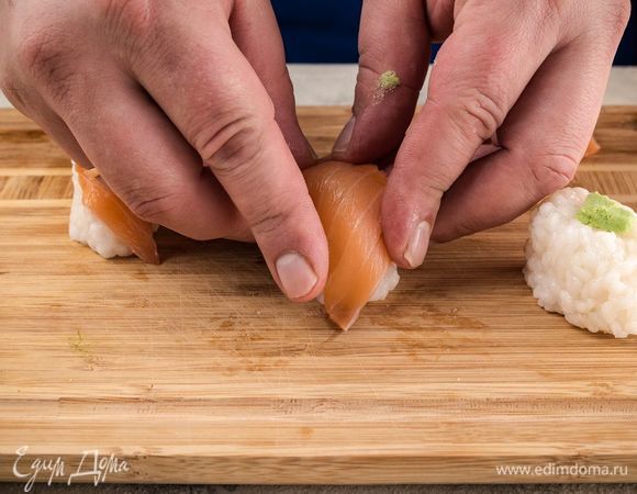 На каждую суши положить немного васаби, выложить полоску форели. 

