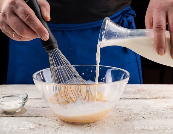 Приготовьте блинное тесто. В глубокой емкости взбейте куриные яйца с солью. Добавьте теплое молоко.