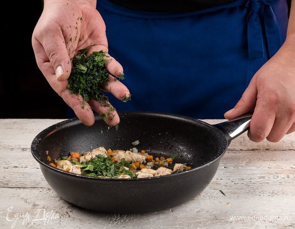 Приготовьте начинку. Для этого нарежьте мелко куриное филе. Также измельчите лук и нарежьте кубиками морковь, обжарьте на оливковом масле до мягкости. Измельчите и добавьте свежую зелень. 