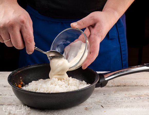 Добавьте к тушеным овощам рис, майонез, соль по вкусу. Все хорошо перемешайте.