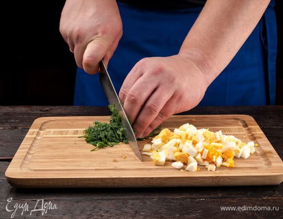 Отварите 3 яйца и нарежьте кубиками. Измельчите зелень. 