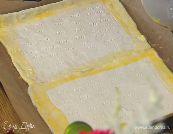 На противень, выстеленный бумагой для выпечки, поместить оба пласта теста, всю поверхность, кроме бортиков, часто наколоть вилкой, а бортики смазать яйцом.