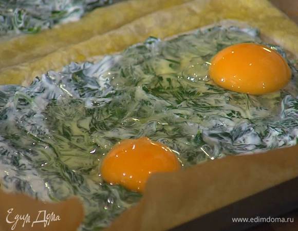 На подпеченные коржи, оставив бортики свободными, равномерно выложить шпинат со сметаной, сверху на каждый пирог разбить по два яйца и немного посолить.