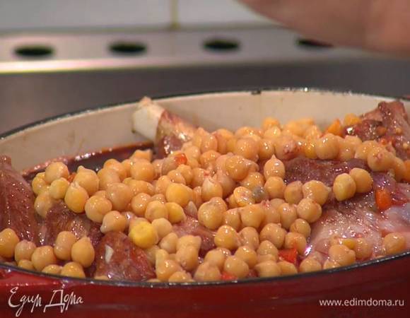 Обжаренное мясо погрузить в овощной соус, сверху равномерно выложить отваренный нут, полить все вином, накрыть крышкой и томить на небольшом огне два — два с половиной часа в зависимости от размера голяшек.