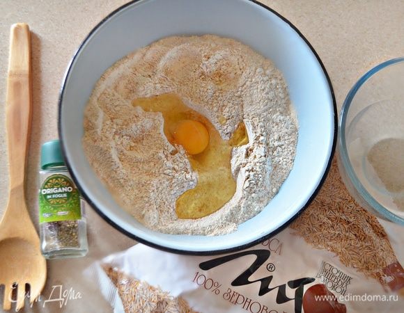 Добавьте яйцо, орегано, теплую воду и перемешайте. Постепенно добавляйте оливковое и чесночное масло (чесночное масло можно заменить, добавив 0,5 ч. л. чесного порошка, растворенного в 1 ст. л. оливкового масла). 