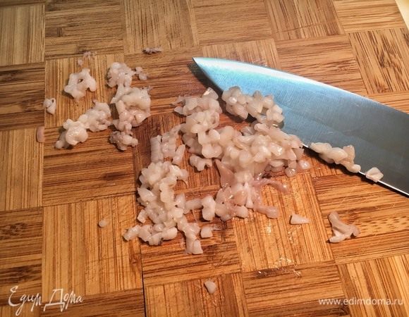 Мелко нарежьте одного кальмара и два щупальца.