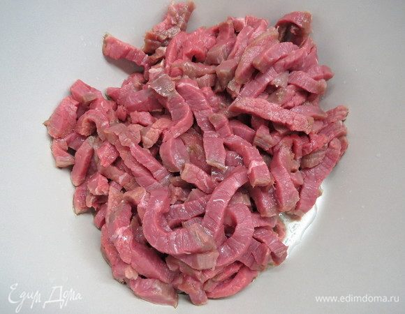 Нарезать пластинами говяжью вырезку, отбить, затем нарезать тонкими брусочками поперек волокон.