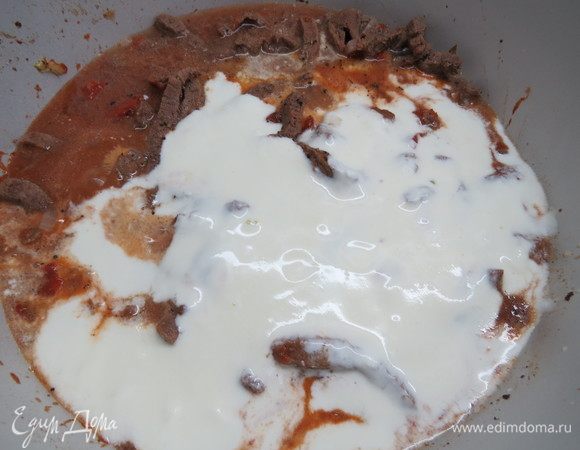 Затем вливаем сметанный соус в мясо, все как следует перемешиваем и тушим под крышкой на небольшом огне 15-20 минут. 