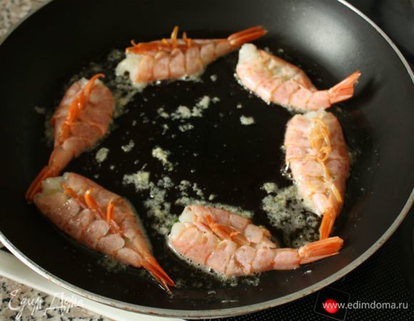 В большой сковороде нагреть 1 ст. л. оливкового масла, затем добавить сливочное. Теперь делаем все очень быстро! В сковороде быстро обжарить аргентинские креветки (разрезом вниз).