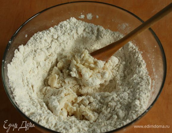 Вылить молочно-масляную смесь к муке и ложкой быстро перемешивать, подгребая муку с периферии. Когда тесто не будет обжигать, начинайте собирать его руками. 
