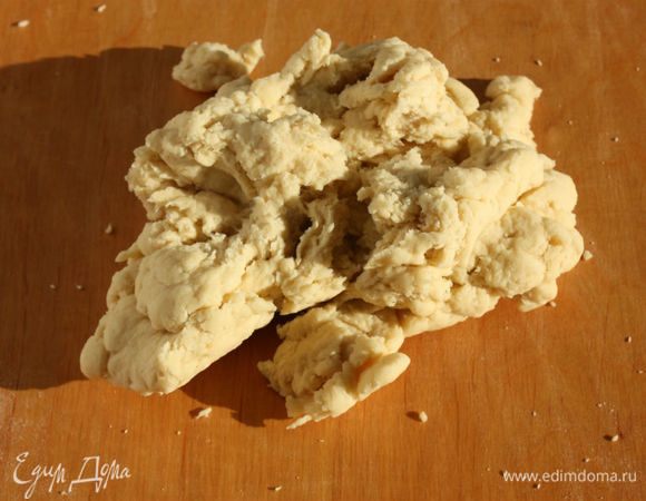 Перенесите тесто на рабочую поверхность и тщательно месите до гладкой консистенции. Поначалу оно рассыпается на кусочки. Мука попадается разная, поэтому, если чувствуете, что жидкости маловато, верните тесто в миску и добавьте немного горячего молока, но не увлекайтесь! Тесто должно быть гладким, но тугим. После тщательного вымешивания сформируйте толстую колбаску, оберните пищевой пленкой и оставьте на 1 час при комнатной температуре.