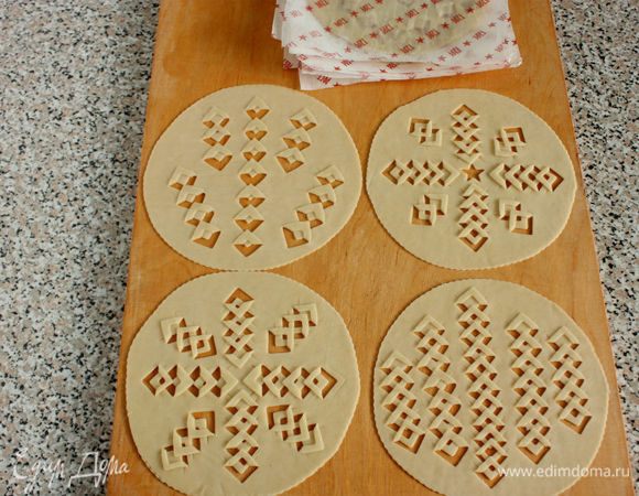 Наколите вилкой тесто в нескольких местах. Диски с узором также складывайте между пергаментом и под полотенце.