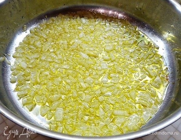 На сковороде раскаляем оливковое масло и обжариваем мелко нарезанный лук до прозрачности.