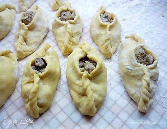 Тщательно защипываем тесто сначала с одного бока, а затем с другого так, чтобы в центре осталось небольшое отверстие. Затем укладываем расстегаи на противень (я выпекаю на силиконовом коврике) и ставим в теплое место для расстойки на 20-30 минут.