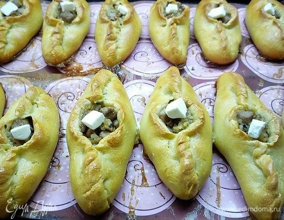 Перед выпечкой смазываем изделия взбитым яйцом и выпекаем в заранее разогретой духовке при 180°С в течение 30 минут. После окончания выпечки в серединку каждого расстегая кладем по кусочку сливочного масла.