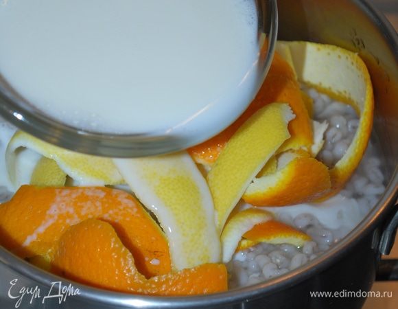 Добавим молоко и будем томить в течение 15-20 минут. Молоко пропитается ароматом цитрусовых и впитается в крупу. Все корки от апельсина и лимона уберем, крупа должна полностью остыть.