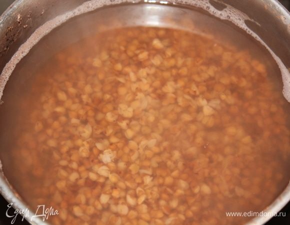 Отварить гречневую крупу так, чтобы она была недоваренной на 3-4 минуты. Включить духовку, установить температуру на 185°C, оставить нагреваться.