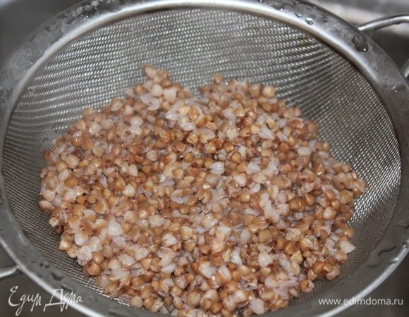 По готовности гречки слить воду через сито. Поставить сито в кастрюлю, чтобы слилась лишняя жидкость, и крупа остыла. 