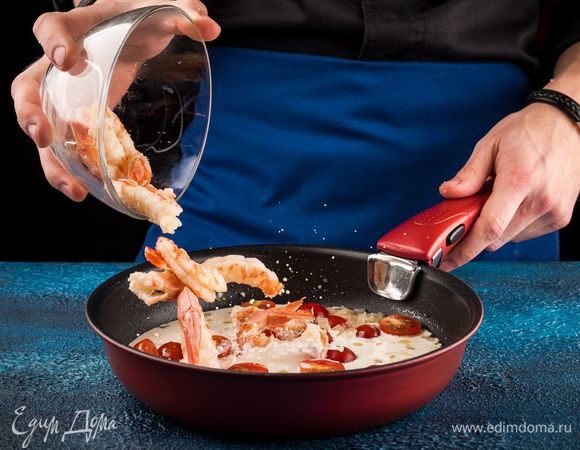 Добавьте в соус креветки, тушите 2 минуты. Тем временем нарежьте свежий базилик.