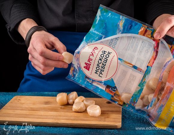 Морские гребешки ТМ «Магуро» разморозить, слить воду и обсушить бумажными полотенцами, нарезать кусочками. Кокотницы смазать оливковым маслом и выложить в них гребешки.