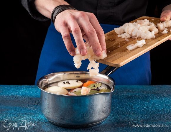 Положите рыбу в кастрюлю, добавьте очищенную морковь, лук, специи. Варите в течение 15 минут.