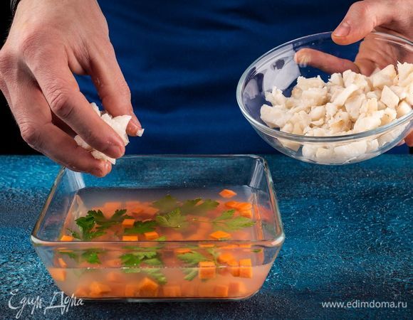 В форму налейте тонким слоем бульон и дайте ему застыть. Затем выложите морковь, зелень. Сверху положите кусочки рыбы и залейте все бульоном до краев. Поставьте формочки в холодильник на несколько часов до полного застывания. Лимон нарежьте тонкими ломтиками, используйте также оставшуюся зелень.