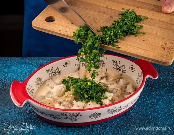 Форму для выпечки пирога смажьте оливковым маслом, вылейте половину теста. Сверху на него выложите ровным слоем рыбу, измельченную зелень.