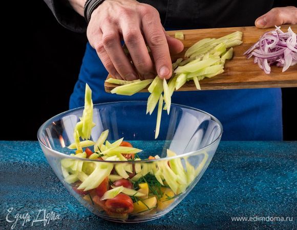 У сладкого перца снять кожицу и удалить семена, мякоть тонко порезать и выложить в салат. С огурцов снять кожуру и тонко их нарезать. Красный лук почистить и нарезать тонкой соломкой. Добавить в салат.
